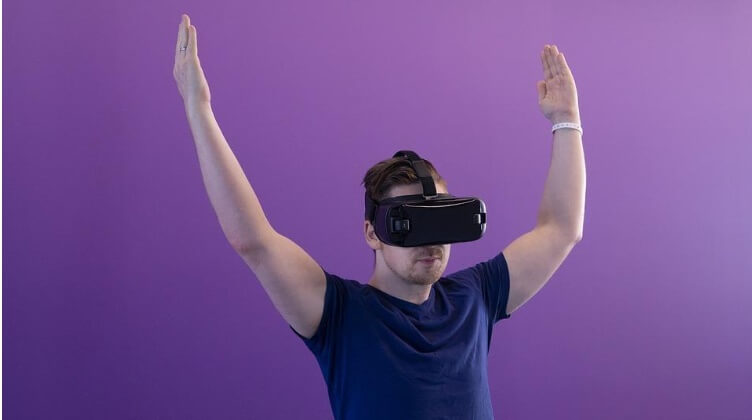 Guy with VR glasses and hands in the air